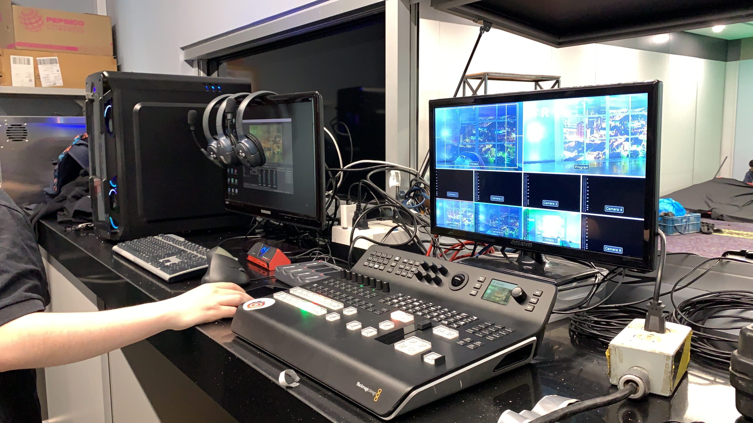 A live production switcher and multi-camera monitor at the broadcast control desk